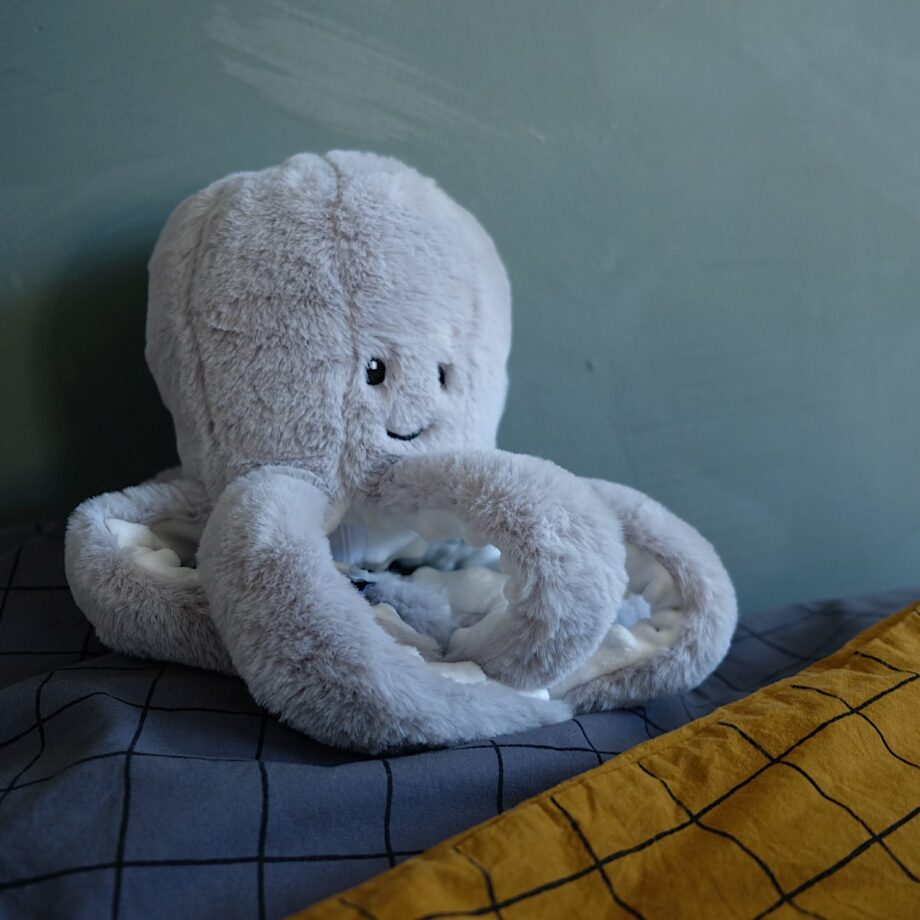 Peluche bruit blanc Olly la Pieuvre - Flow Amsterdam - Ce comforteur est le doudou indispensable pour votre enfant. Grâce à son petit boitier, il apaise en restituant le son d'un cours d’eau, d'un battement de coeur ou d'une mélodie.